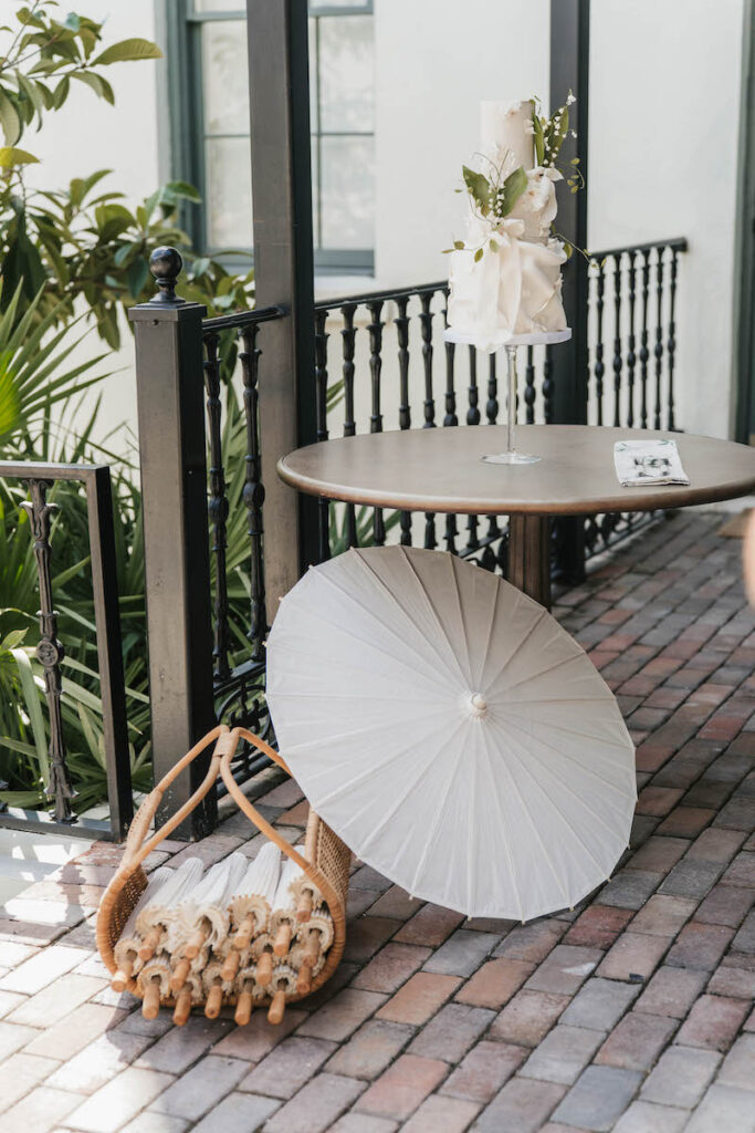 The Lily of the Valley themed cake sits with a basket of paper parisols